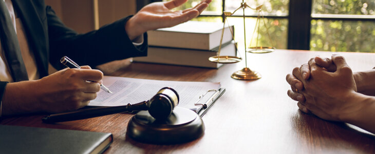 Lawyer meeting with a client at a desk with a gavel