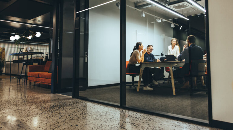 Business colleagues having a meeting in a transparent boardroom. Group of happy business professionals having a discussion during a briefing. Diverse businesspeople collaborating on a new project. business and real estate sombathy law firm