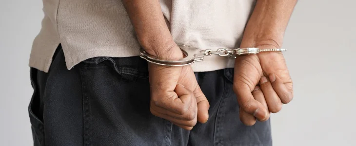 Man with hands behind his back cuffed