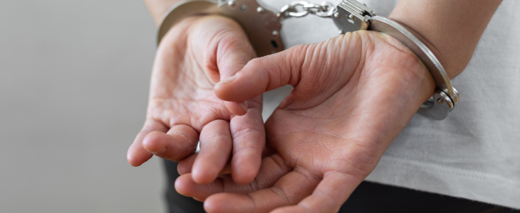 Close up of person's hands in handcuffs