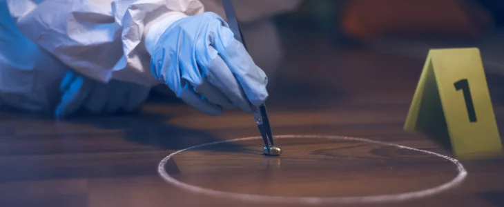 forensic scientist picking up bullet at murder crime scene