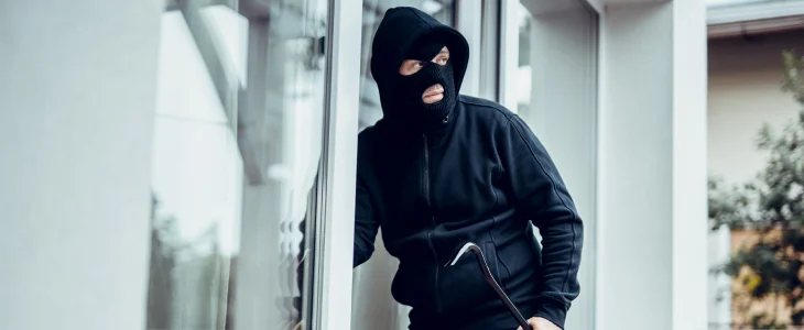 Person dressed in all black breaking into a home