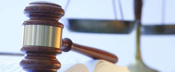 Mallet on the table next to scales to represent justice