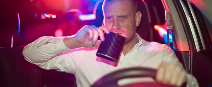 Male driver with flask being pulled over by police