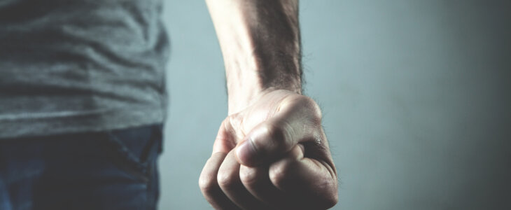 Caucasian angry and aggressive man threatening with fist