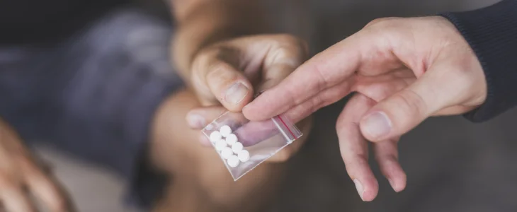 Drug dealer selling ecstasy pills to a drug addict