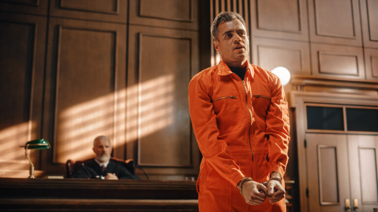 Portrait of Accused Male Criminal in Orange Jumpsuit