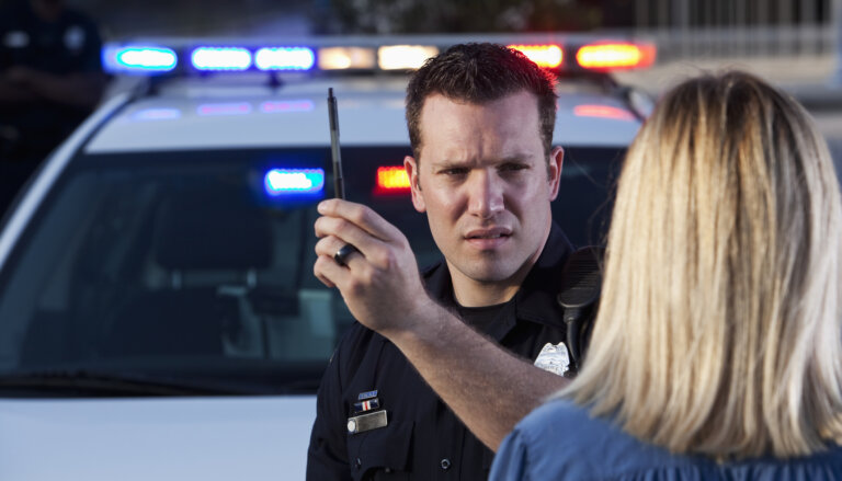 Police officer conducting sobriety test on woman.