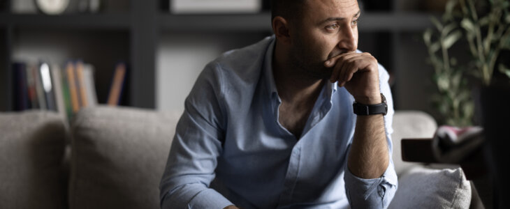 Man sitting on couch looking sad