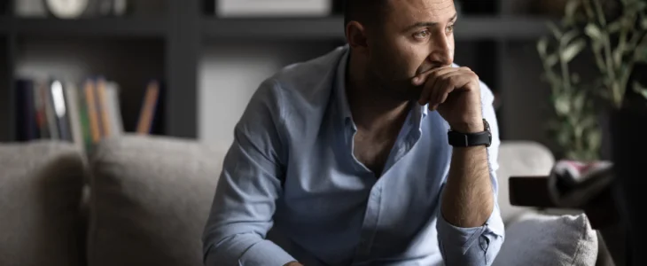 Man sitting on couch looking sad