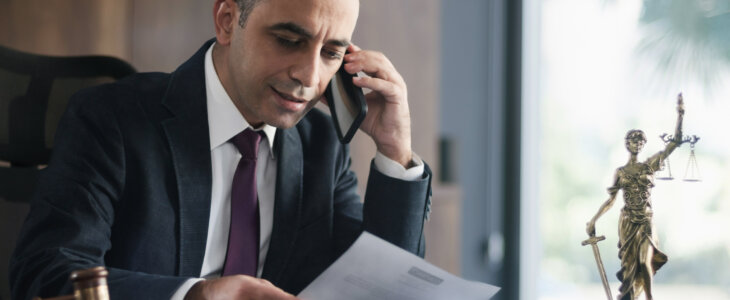 Legal consultant lawyer having a phone conversation with his client in his office.